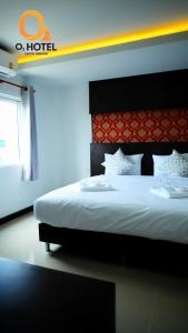 色军O2 Hotel สกลนคร (โรงแรม โอทู สกลนคร)的一间卧室配有一张白色大床和红色床头板