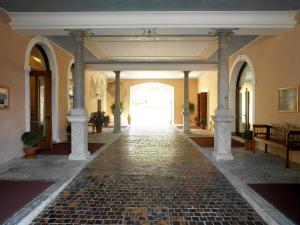 戈里齐亚英托拉格大酒店 - 斯特拉索多宫 的建筑中带有石地板和柱子的走廊