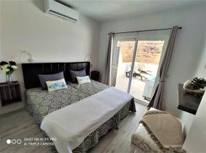 San PedroLa Casita de Juani,La Suerte的一间卧室设有一张大床和一个滑动玻璃门
