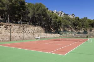 普罗旺斯地区萨隆Best Western Domaine de Roquerousse的网球场,上面设有长凳