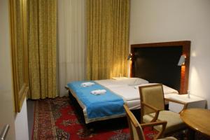 柏林加尼阿贝纳酒店的酒店客房带一张床、一张桌子和椅子