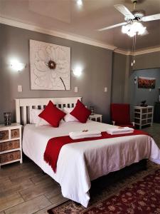 波切夫斯特鲁姆Graceland Guesthouse的一间卧室配有一张带红色枕头的大床