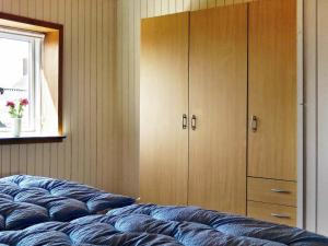 莱姆维Two-Bedroom Holiday home in Lemvig 5的一间卧室配有床、橱柜和窗户