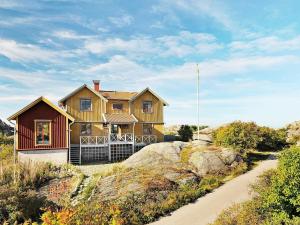 谢尔港12 person holiday home in Sk rhamn的山丘上的房子,前面有一条小径