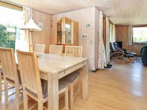 格隆霍Three-Bedroom Holiday home in Løkken 41的一间带木桌和椅子的用餐室