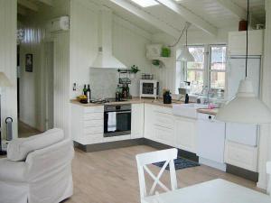 布罗艾厄Three-Bedroom Holiday home in Broager 4的一间带白色橱柜的厨房和一间客厅