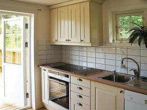 Arkösund维克博兰德两卧室度假屋 的厨房配有白色橱柜和水槽