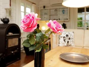 莱斯6 person holiday home in L s的一张桌子上满是粉红色玫瑰的花瓶