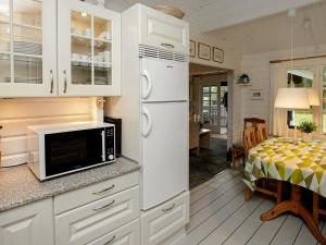 莱斯6 person holiday home in L s的一间带白色冰箱的厨房和一间用餐室