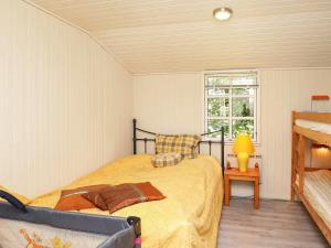 格莱斯堡6 person holiday home in Glesborg的一间卧室配有一张床、一张桌子和一个窗户。