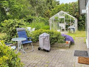 Strøby Egede4 person holiday home in K ge的一个带桌椅和温室的花园