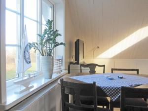 Romelanda4 person holiday home in Romelanda的一间带桌子和窗户的用餐室