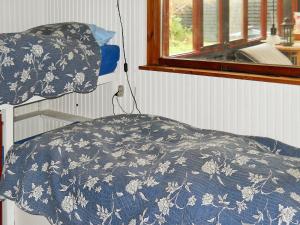 吉利勒杰Holiday Home Revlingestien III的一张带蓝色和白色毯子的床,配有窗户