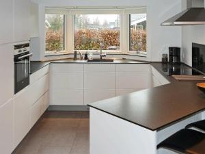 诺尔赫鲁普Holiday Home Brøndbækken II的厨房配有白色橱柜和黑色台面