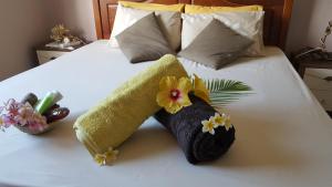 弗利康弗拉克Aux plaisirs de la vie的一张带两条毛巾和鲜花的床