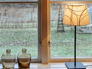 Västra Tunhem8 person holiday home in Varg n的窗台上的一盏灯和两瓶玻璃花瓶