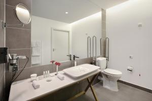 柏林柏林波茨坦广场皇冠假日酒店的白色的浴室设有水槽和卫生间。