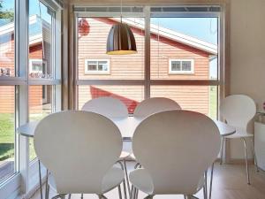 古兹耶姆6 person holiday home in Gudhjem的一间配备有白色桌椅的用餐室