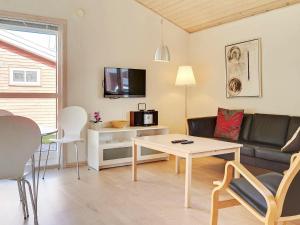 古兹耶姆6 person holiday home in Gudhjem的客厅配有沙发和桌子