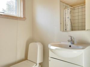 古兹耶姆6 person holiday home in Gudhjem的白色的浴室设有水槽和卫生间。