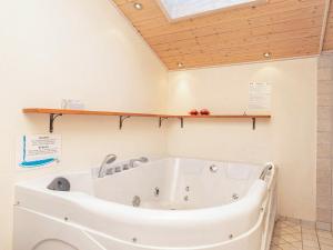 灵克宾6 person holiday home in Ringk bing的带浴缸的浴室和木制天花板