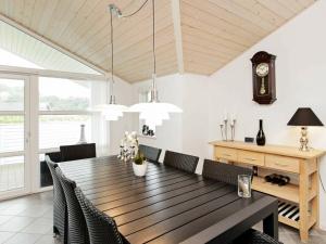 安斯艾厄Holiday Home Søgårdsvej IV的一间带木桌和椅子的用餐室