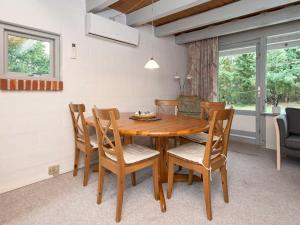 Øksenmølle5 person holiday home in Ebeltoft的一间带木桌和椅子的用餐室