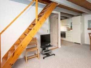 Øksenmølle5 person holiday home in Ebeltoft的带楼梯的客房,配有电视和厨房