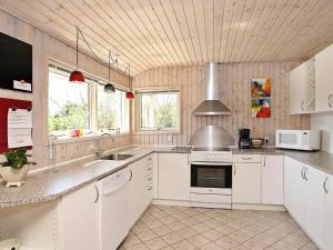 伦斯楚普8 person holiday home in Hj rring的厨房配有白色橱柜和水槽