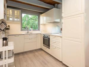 Øksenmølle5 person holiday home in Ebeltoft的白色的厨房配有白色橱柜和窗户