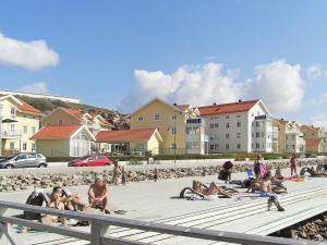 吕瑟希尔One-Bedroom Holiday home in Lysekil 9的一群人坐在海滩上,有建筑