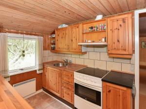 朗尼赫德8 person holiday home in N rre Nebel的厨房配有木制橱柜、炉灶和窗户。
