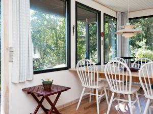 锡尔克堡4 person holiday home in Silkeborg的一间带桌椅和窗户的用餐室