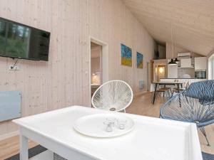 伦斯楚普9 person holiday home in Hj rring的客厅配有白色桌子和电视