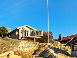 Hällsvik2 person holiday home in TORSLANDA的山顶上带旗杆的房子