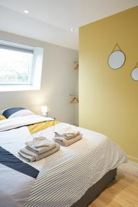 图尔昆LocationsTourcoing - Le Famelart的一间卧室配有带毛巾的床