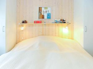 TranekærHoliday home Tranekær IV的卧室配有白色的床和木制床头板