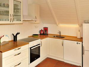 朗尼赫德Three-Bedroom Holiday home in Nørre Nebel 16的厨房配有白色橱柜和水槽