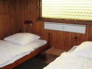 格隆霍洛肯25号两卧室度假屋的带窗户的客房内设有两张单人床。