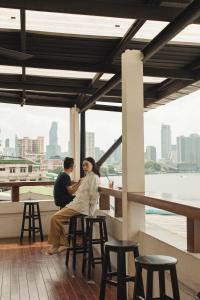 曼谷尔毕旅舍的坐在阳台凳子上的男人和女人