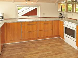 安斯艾厄7 person holiday home in Ansager的厨房配有木制橱柜和窗户。