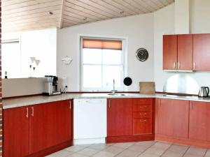 博利尔马克勒姆8号四卧室度假屋的厨房配有木制橱柜和窗户。