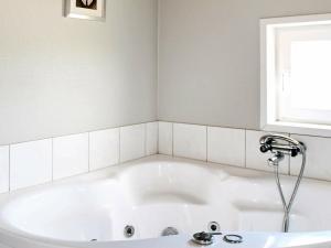 博利尔马克勒姆8号四卧室度假屋的带窗户的浴室内的白色浴缸