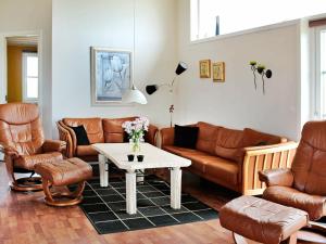 博利尔马克勒姆8号四卧室度假屋的客厅配有皮革家具和桌子