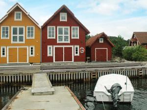 ErvikFour-Bedroom Holiday home in Urangsvåg的停靠在房屋前的码头的船只
