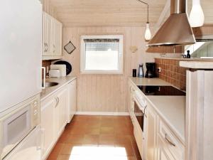 海默特6 person holiday home in Hemmet的厨房配有白色橱柜和窗户。