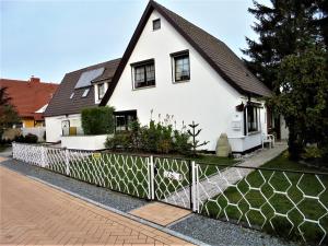 青斯特Ferienwohnungen/Ferienzimmer Seidel的前面有栅栏的白色房子