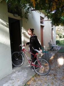 乌尔巴尼亚nel cuore della città的女人站在门外,坐在自行车旁