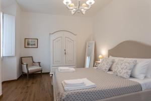 普拉托Mercatale Apartment的一间卧室配有一张床、一把椅子和一个吊灯。