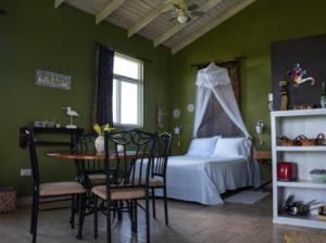 Calibishie杰克维旅馆的卧室配有一张床和一张桌子及椅子